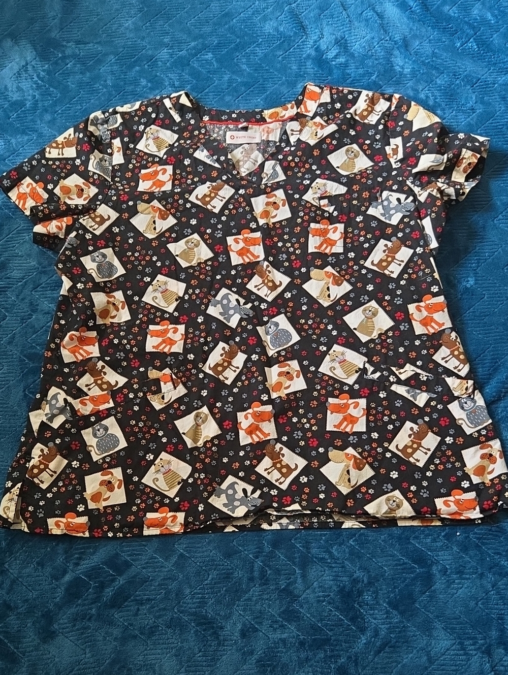 White Cross Women's Black Scrub Top with Orange, Brown and Cream Cartoon Print